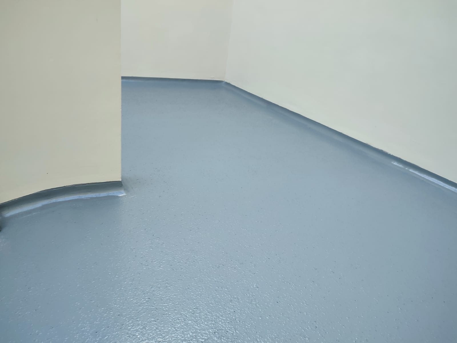 13. Continuidad del recubrimiento. El piso y el zoclo sanitario forman una sola superficie continua, resistente y de fácil mantenimiento.