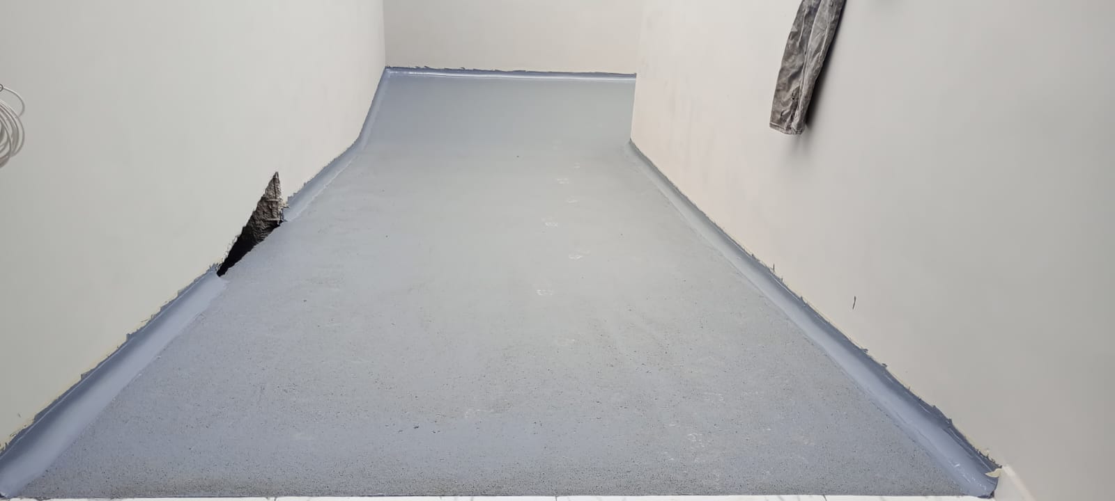 6. Integración del piso y los muros. Se termina de unir el recubrimiento con el zoclo sanitario para evitar esquinas difíciles de limpiar.